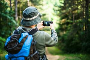 imagen de hombre disfruta excursionismo y haciendo imágenes con su teléfono foto