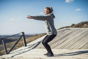 mujer disfruta hacer ejercicio a el antiguo de madera puente en naturaleza foto