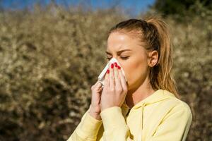 Woman blowing nose while spending time in the nature photo