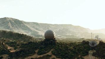 A massive surveillance antenna on a vibrant green hilltop video