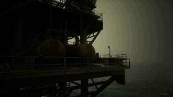 A massive oil rig towering above the ocean on a pier video