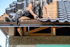 construction work on the roof of a family house, fired ceramic tiles on wooden beams photo