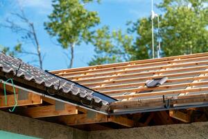 construction of the roof of a new family house on wooden beams made of ceramic tiles photo