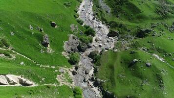 aerial view of green grass with rocks in the middle video