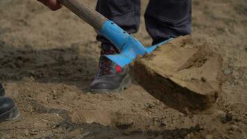 dichtbij omhoog van mans handen in handschoenen en graven een Schep in de tuin video