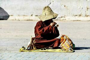 a monk playing a flute in the street photo