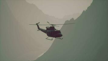 een helikopter vliegend over- een berg met een lucht achtergrond video