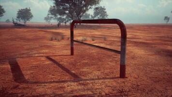 un' rustico rosso sporco campo con un' affascinante recinto e alberi nel il sfondo video