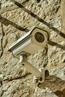 a security camera mounted on a stone wall photo