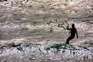 a man kiteboarding in the ocean photo