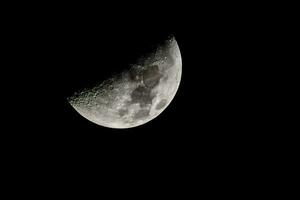 the moon is seen in the dark sky photo