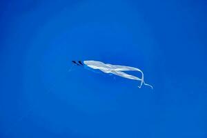 a kite flying in the blue sky photo