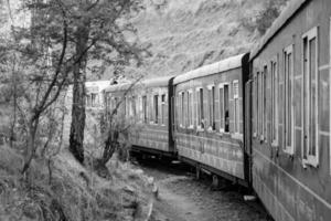 Shimla, Himachal Pradesh, India - August 14, 2023 - Toy train Kalka-Shimla route, moving on railway to the hill, Toy train from Kalka to Shimla in India among green natural forest photo