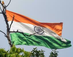 India flag flying high at Connaught Place with pride in blue sky, India flag fluttering, Indian Flag on Independence Day and Republic Day of India, tilt up shot, Waving Indian flag, Har Ghar Tiranga photo