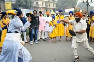 Delhi, India, October 2, 2023 - Sikhs display gatka and martial arts during annual Nagar Kirtan, Traditional, procession on account of birthday of Guru Nanak Dev ji, Nagar Kirtan in East Delhi area photo