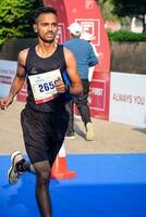 nuevo Delhi, India - octubre 15 2023 - vedanta Delhi medio maratón carrera después codicioso en cuales maratón Participantes acerca de a cruzar el terminar línea, Delhi medio maratón 2023 foto