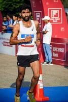 nuevo Delhi, India - octubre 15 2023 - vedanta Delhi medio maratón carrera después codicioso en cuales maratón Participantes acerca de a cruzar el terminar línea, Delhi medio maratón 2023 foto