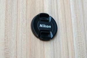 New Delhi, India, October 8 2023 - Nikon lens cap on plain background, Nikon DSLR kit shoot photo