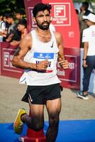 New Delhi, India - October 15 2023 - Vedanta Delhi Half Marathon race after covid in which marathon participants about to cross the finish line, Delhi Half Marathon 2023 photo