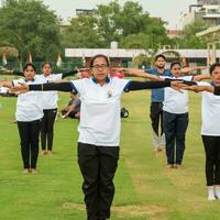 nuevo Delhi, India, junio 21, 2023 - grupo yoga ejercicio sesión para personas a yamuna Deportes complejo en Delhi en internacional yoga día, grande grupo de adultos asistiendo yoga clase en Grillo estadio foto