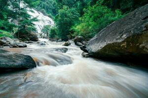 Beautiful waterfall in lush tropical green forest. Nature landscape. Mae Ya Waterfall is situated in Doi Inthanon National Park, Chiang Mai, Thailand. Waterfall flows through jungle on mountainside. photo