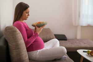 Sad pregnant woman doesn't want to eat vegetables photo