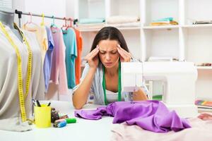 Seamstress is having headache while working at workshop photo