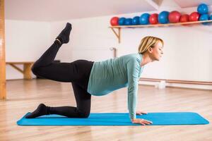 Pregnant woman enjoys exercising yoga photo