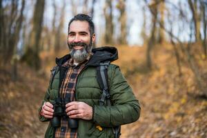 Image of man hiking and using binoculars photo