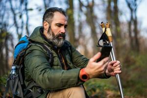 Image of hiker using phone while spending time in nature photo