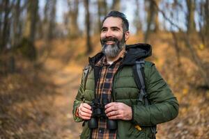 Image of man hiking and using binoculars photo