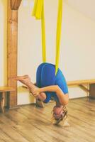 Woman doing aerial yoga in the fitness studio photo