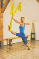 Woman doing aerial yoga in the fitness studio photo