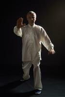 Senior man enjoys exercise Tai Chi indoor photo