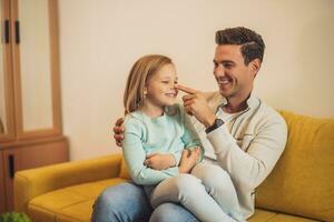 Happy father and daughter spending time together and having fun at their home photo