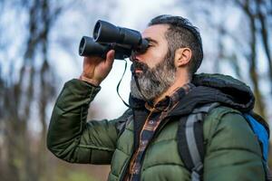 Image of man hiking and using binoculars photo