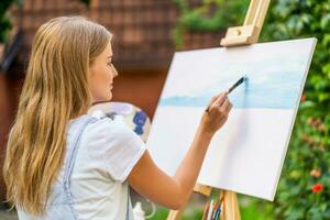 Woman enjoys woman painting on canvas outdoor photo