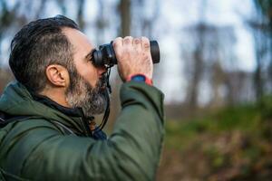 Image of man hiking and using binoculars photo