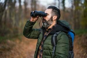 Image of man hiking and using binoculars photo