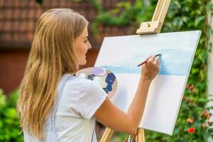 Woman enjoys woman painting on canvas outdoor photo