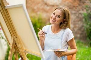 mujer disfruta mujer pintura en lona al aire libre foto