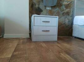 white chest of drawers on the floor in the interior of the room photo