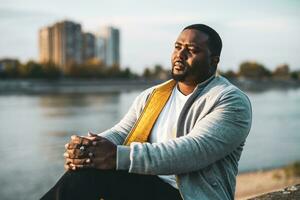 Depressed black man sitting outdoor photo