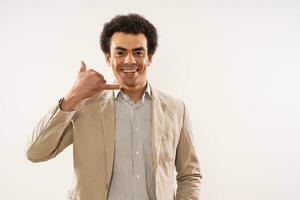 Portrait of happy and successful businessman showing call me gesture photo