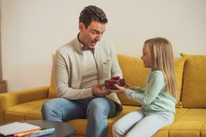 Happy father is getting gift from his daughter photo