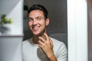 Man using perfume while looking himself in the mirror photo