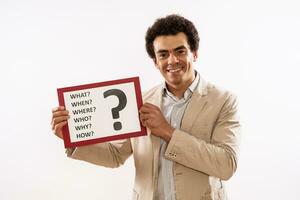 Image of businessman holding paper with question mark and various questions photo