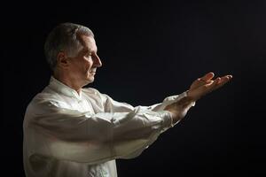 Senior man enjoys exercise Tai Chi indoor photo