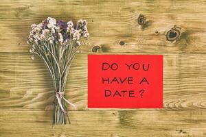 Bouquet of flowers with question do you have a date on wooden table photo