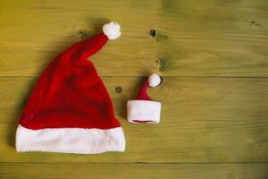 Image of big and small Santa Hat on wooden table photo